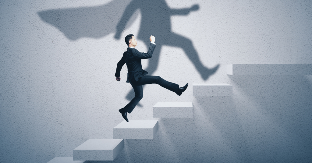 Man climbing stairs with superhero shadow representing how to overcome rejection and rebuild confidence during job search process
