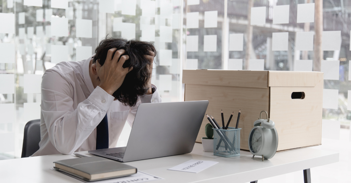 Stressed job seeker sitting at desk with head in hands, laptop open, symbolizing chaotic job search and missed opportunities