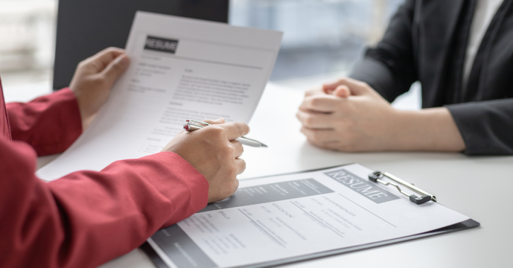 How to prepare for a job interview, hiring manager reviewing a candidate’s resume and preparing answers, illustrating the importance of preparation and documentation.